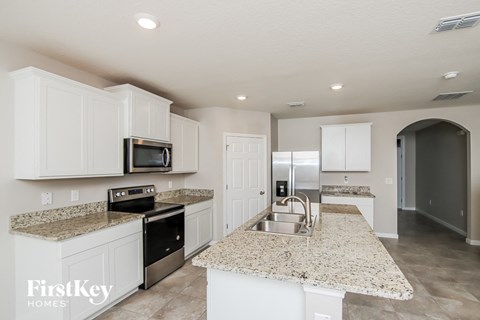 a kitchen with white cabinets and granite counter tops