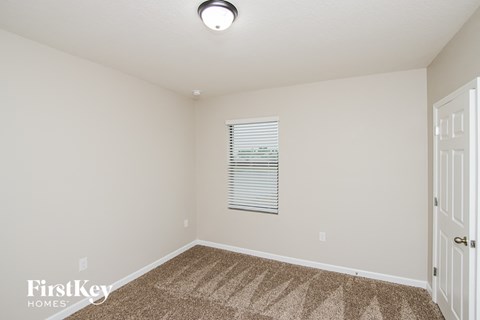 a spacious room with carpeted flooring and a white door