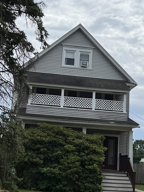 the front of a house with a porch on top of it