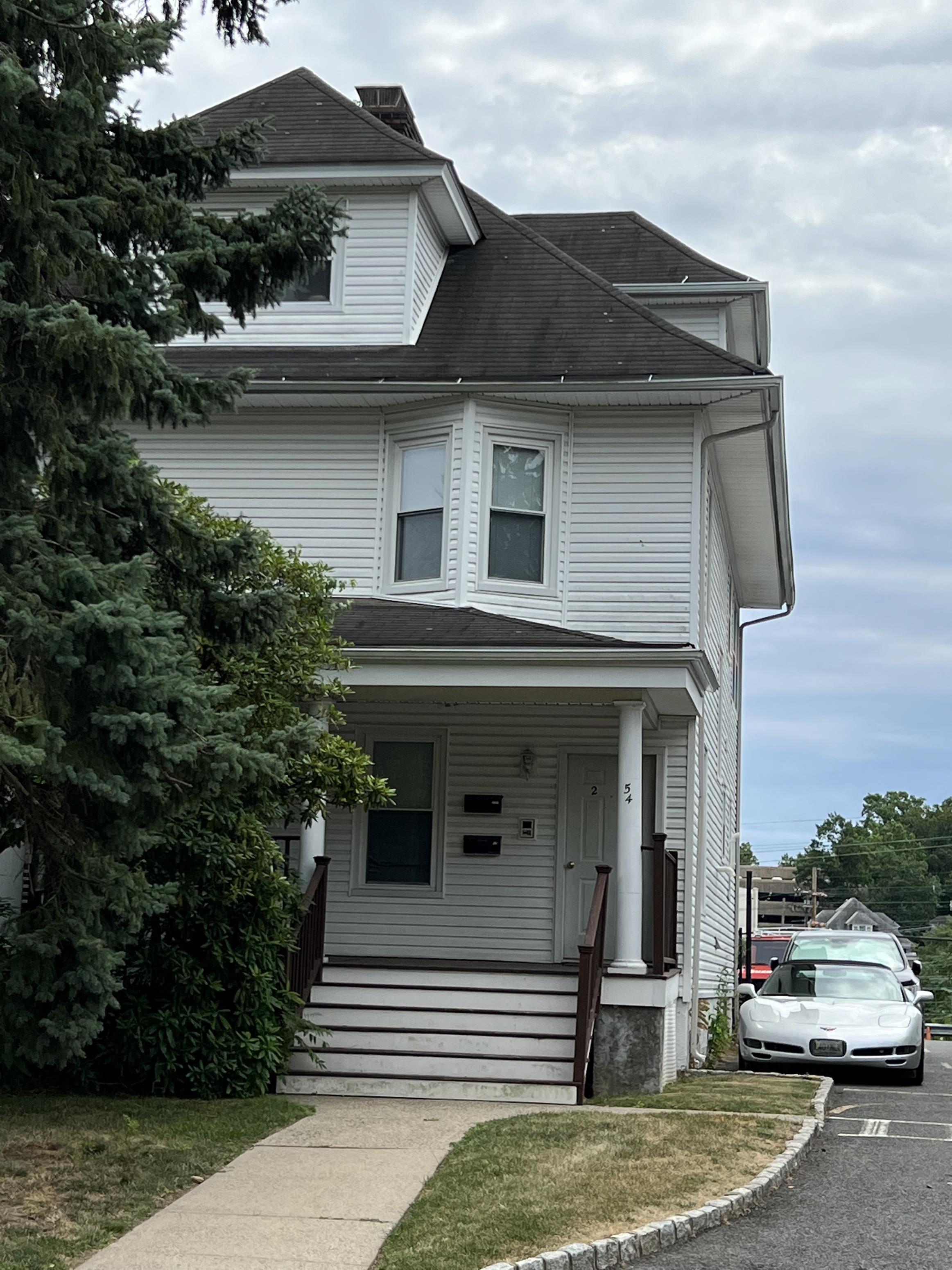 a white house with a car parked in front of it
