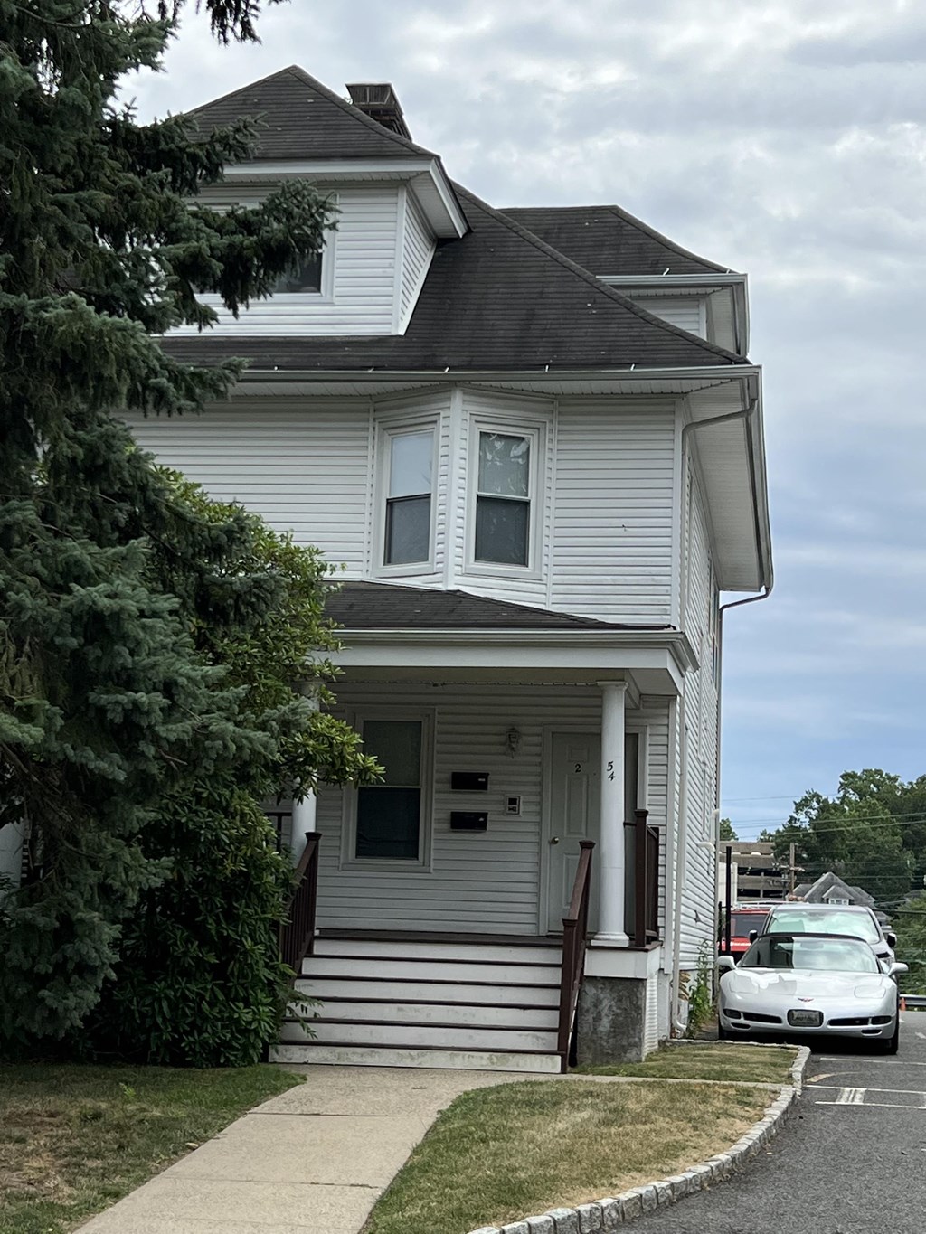 a white house with a car parked in front of it