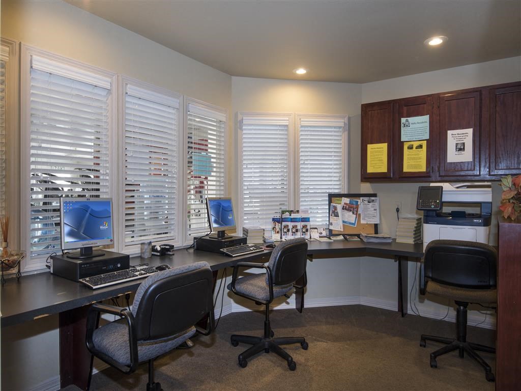 an office with two desks with computers and chairs