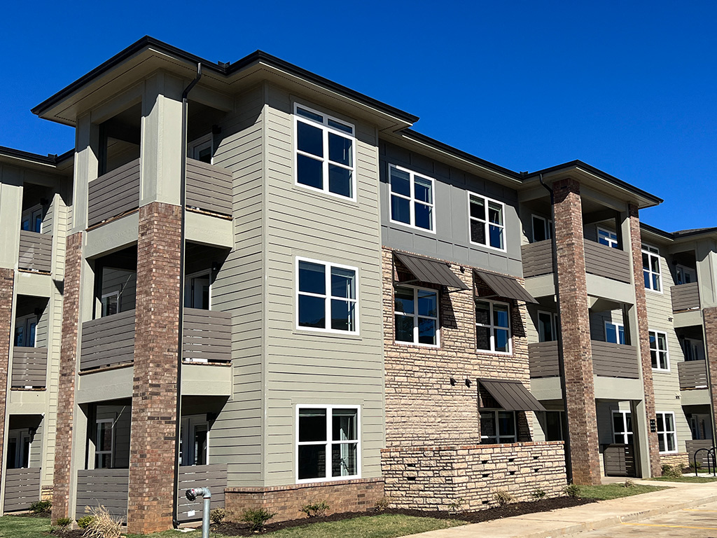 an apartment building with brick and tan siding