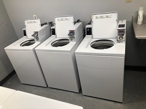 Three white toilets are lined up in a row.
