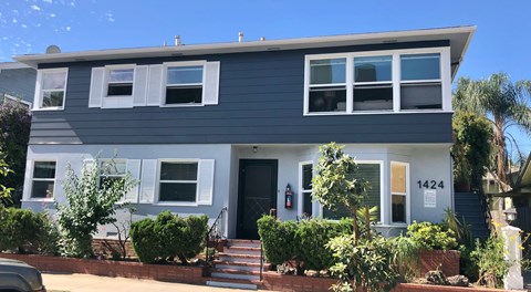A two-story house with a grey facade and white trim.