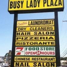 a sign for a busy lady plaza on the side of the street