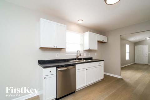 a kitchen with white cabinets and a stainless steel dishwasher
