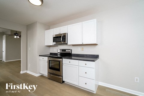 a kitchen with white cabinets and a stove and a microwave