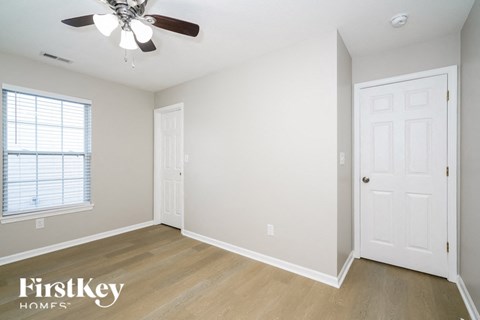 an empty bedroom with a ceiling fan and a closet