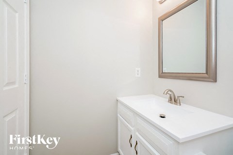 a white bathroom with a sink and a mirror