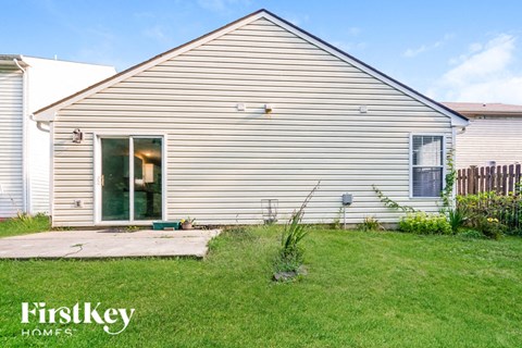 the outside of a white house with a yard and grass