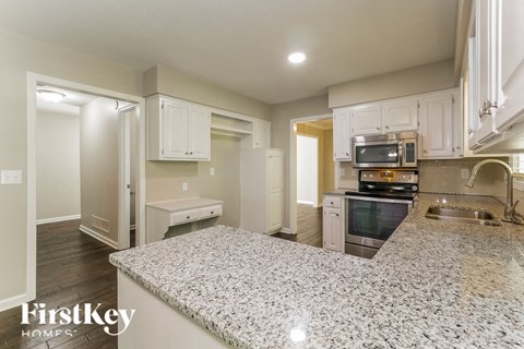 a kitchen with white cabinets and a granite counter top