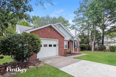 a small brick house with a white garage door