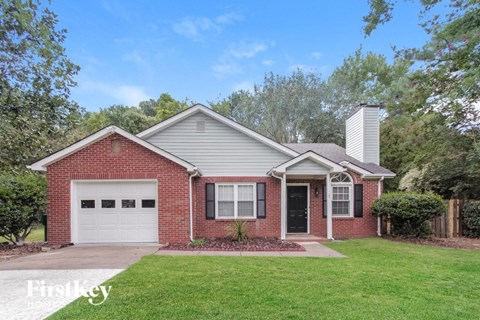 a brick house with a lawn and a white garage door