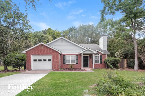 a brick house with a white garage door and a lawn