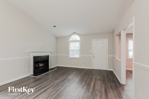 an empty living room with a fireplace and a door