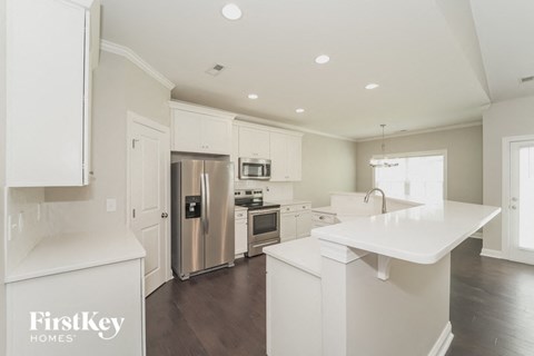 A modern kitchen with white cabinets and appliances.