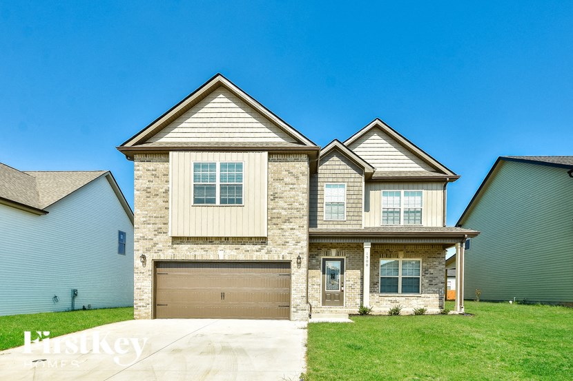 a tan brick house with a brown garage door