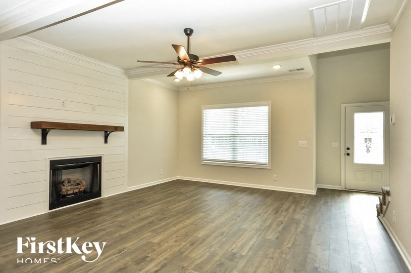 a living room with a fireplace and a ceiling fan