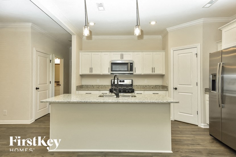 a kitchen with white cabinets and a counter top