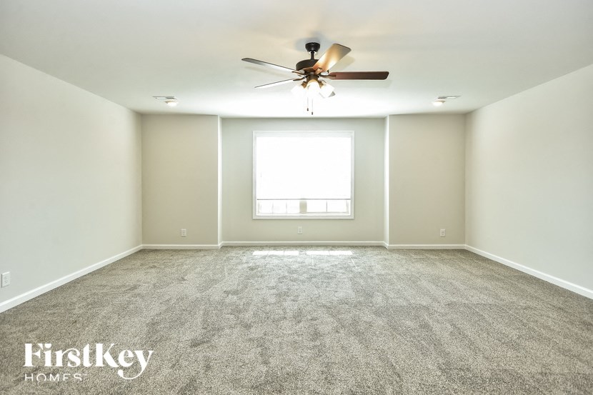 a empty room with a ceiling fan and a window