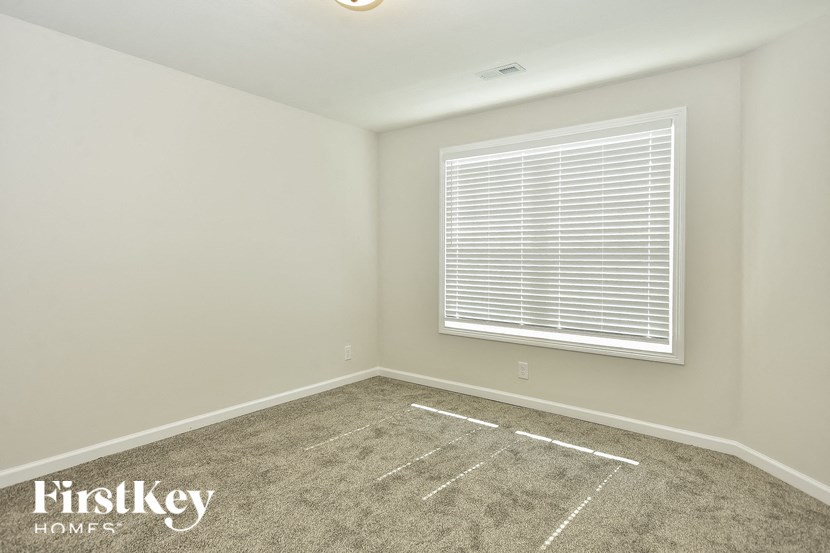 a empty room with a window and a carpet