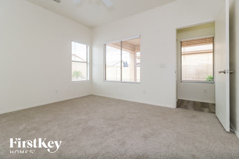 a bedroom with a carpeted floor and two windows