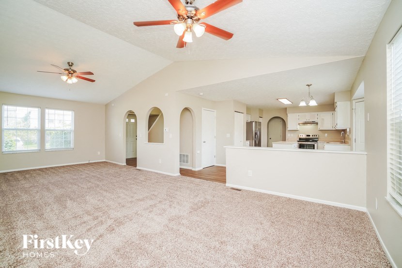 A spacious room with a ceiling fan and carpeted floor.