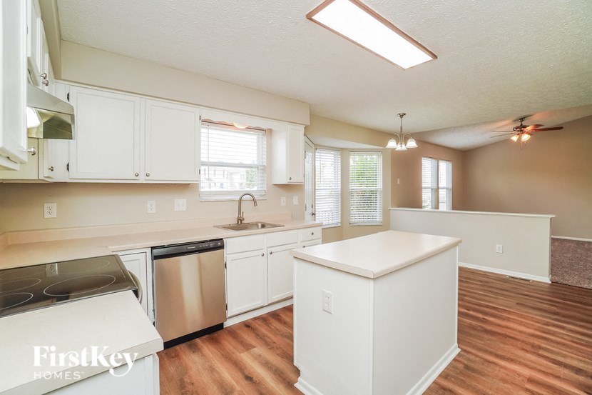 A kitchen with white cabinets and a stainless steel dishwasher.