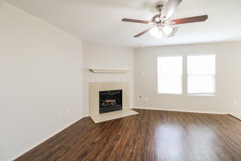a living room with a fireplace and a ceiling fan