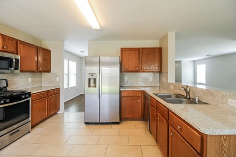 a kitchen with wooden cabinets and a stainless steel refrigerator