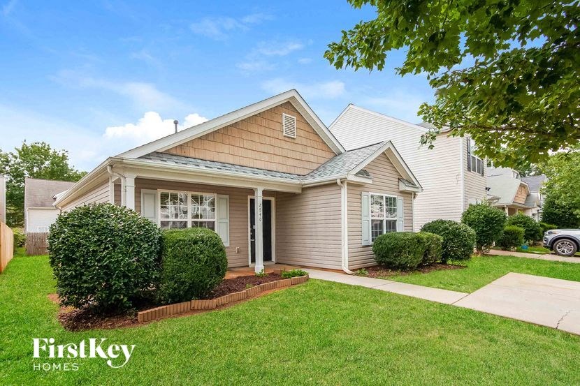 the front of a house with a lawn and a sidewalk