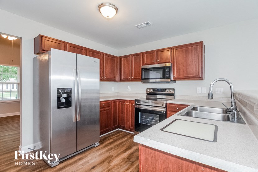 a kitchen with wooden cabinets and a stainless steel refrigerator