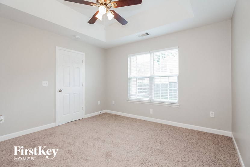 a bedroom with a ceiling fan and a window
