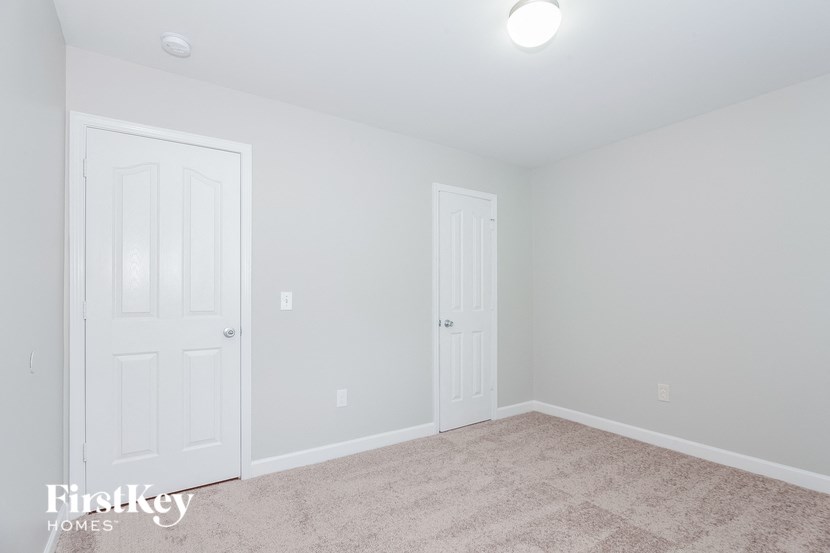 a bedroom with two closets and a carpeted floor