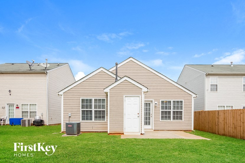 a white house with a white door in front of a green yard