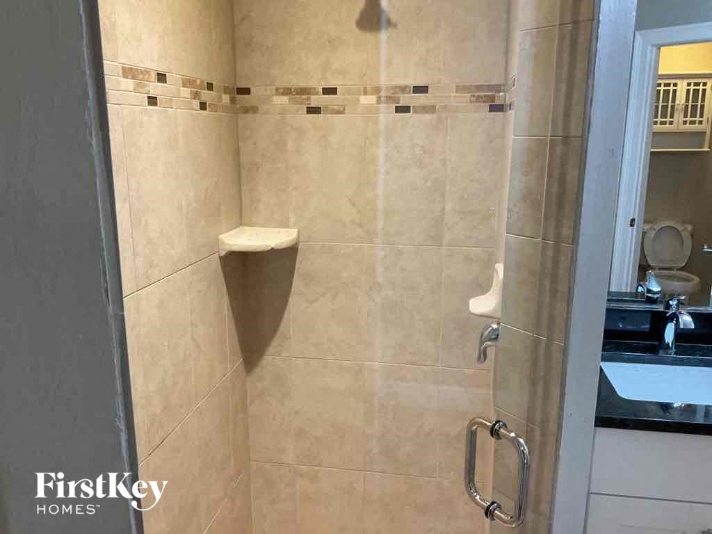 A bathroom with a shower and a toilet.