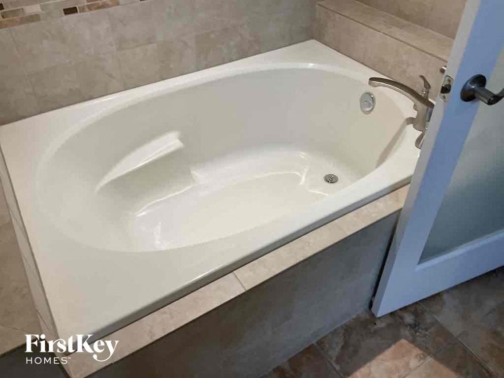 A white bathtub with a faucet is in a bathroom.