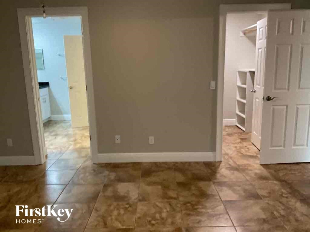 A room with a tiled floor and two doors, one of which is open.