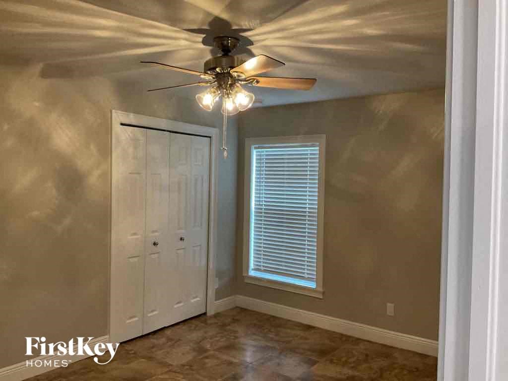 A room with a ceiling fan and a door.