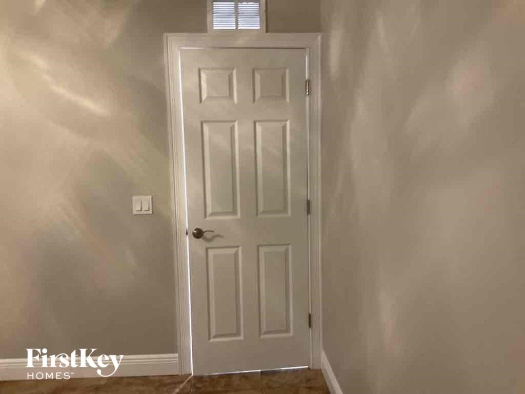 A white door in a room with light shining through a window.
