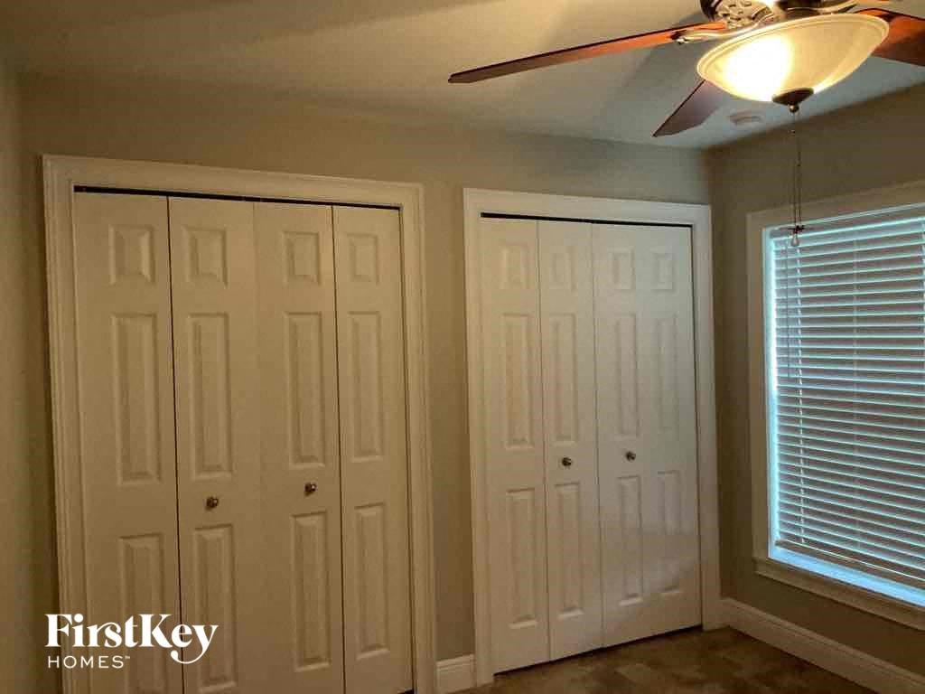 A room with a ceiling fan and two white doors.