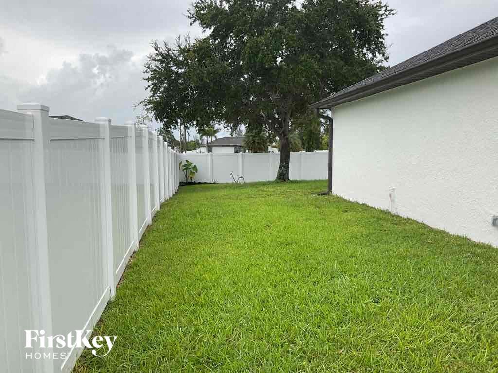 A white fence borders a grassy yard.