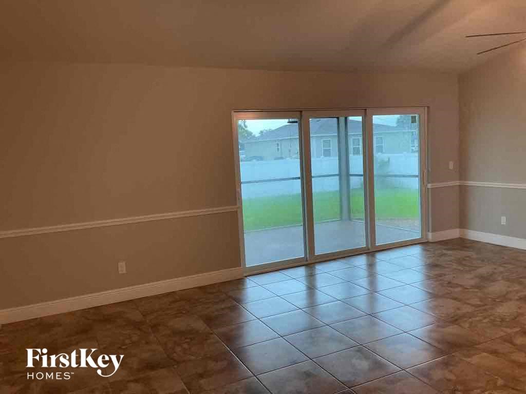 A room with a tile floor and a sliding glass door leading to a backyard.