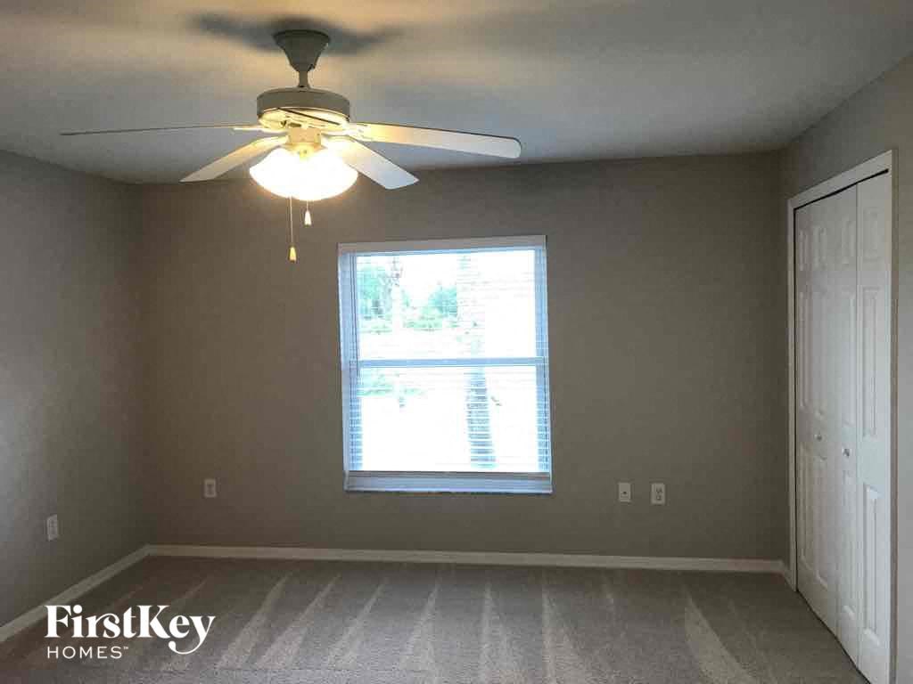 a bedroom with a ceiling fan and a window