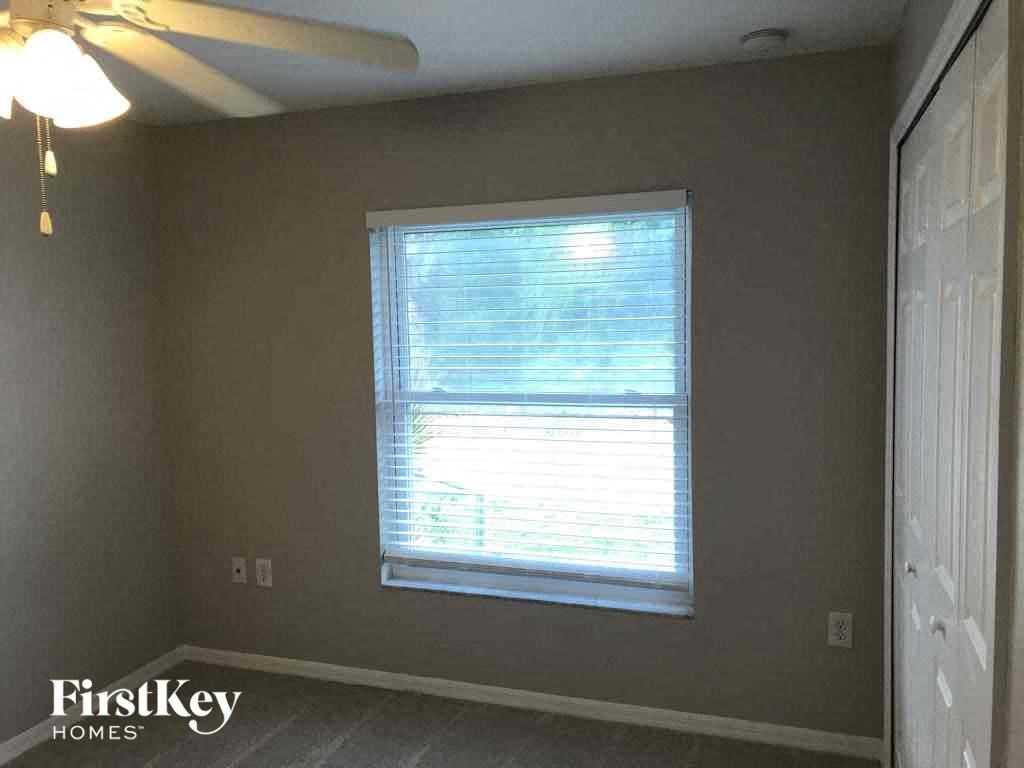a bedroom with a window and a ceiling fan