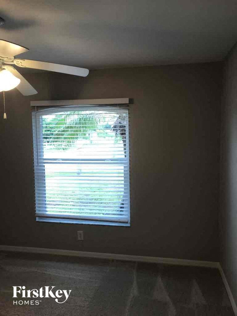 a living room with a window and a ceiling fan