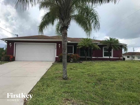 palm trees in front of a house with a white garage door