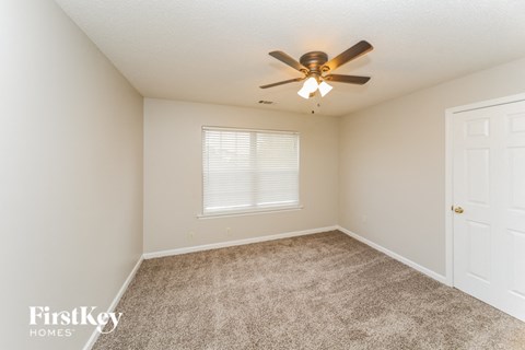 a bedroom with a ceiling fan and a window