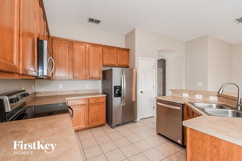 A kitchen with wooden cabinets and a stainless steel refrigerator.